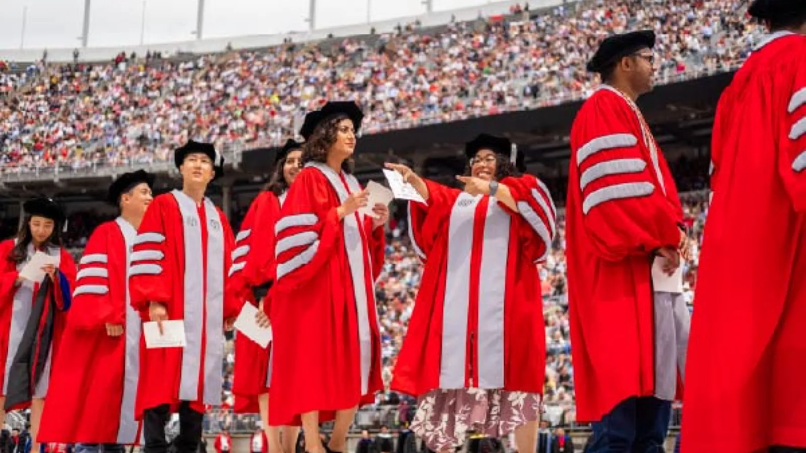 Several PhD recipients in Scarlet and Gray academic regalia at graduation in the Shoe
