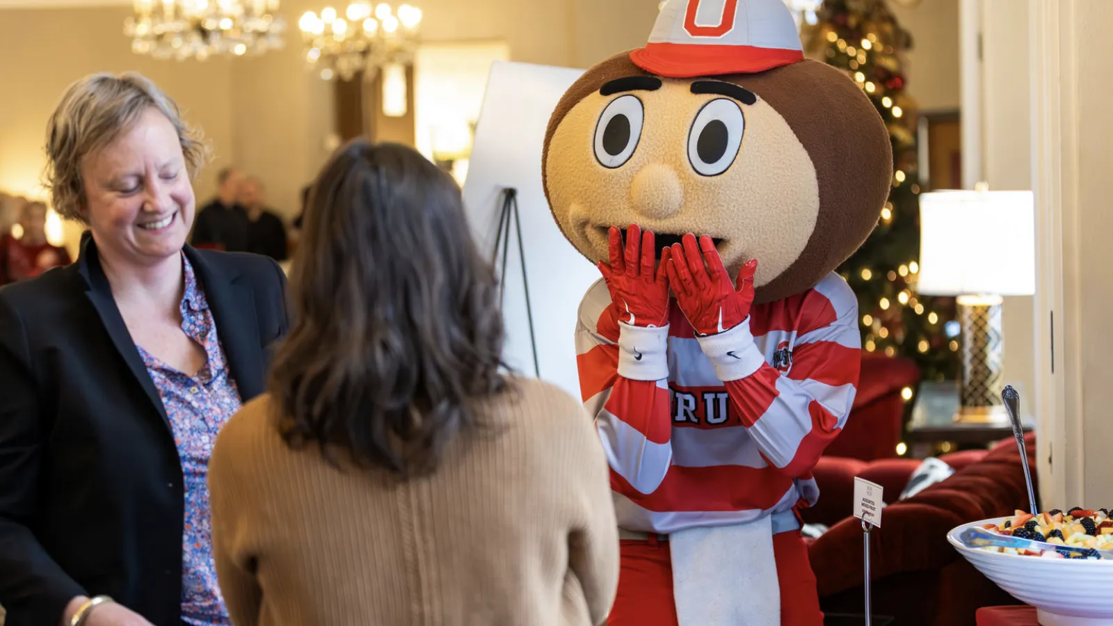 Sarah Harford and Rin Reczek laughing with Brutus Buckeye