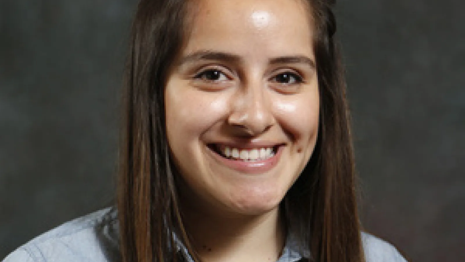 Female graduate student smiles at camera