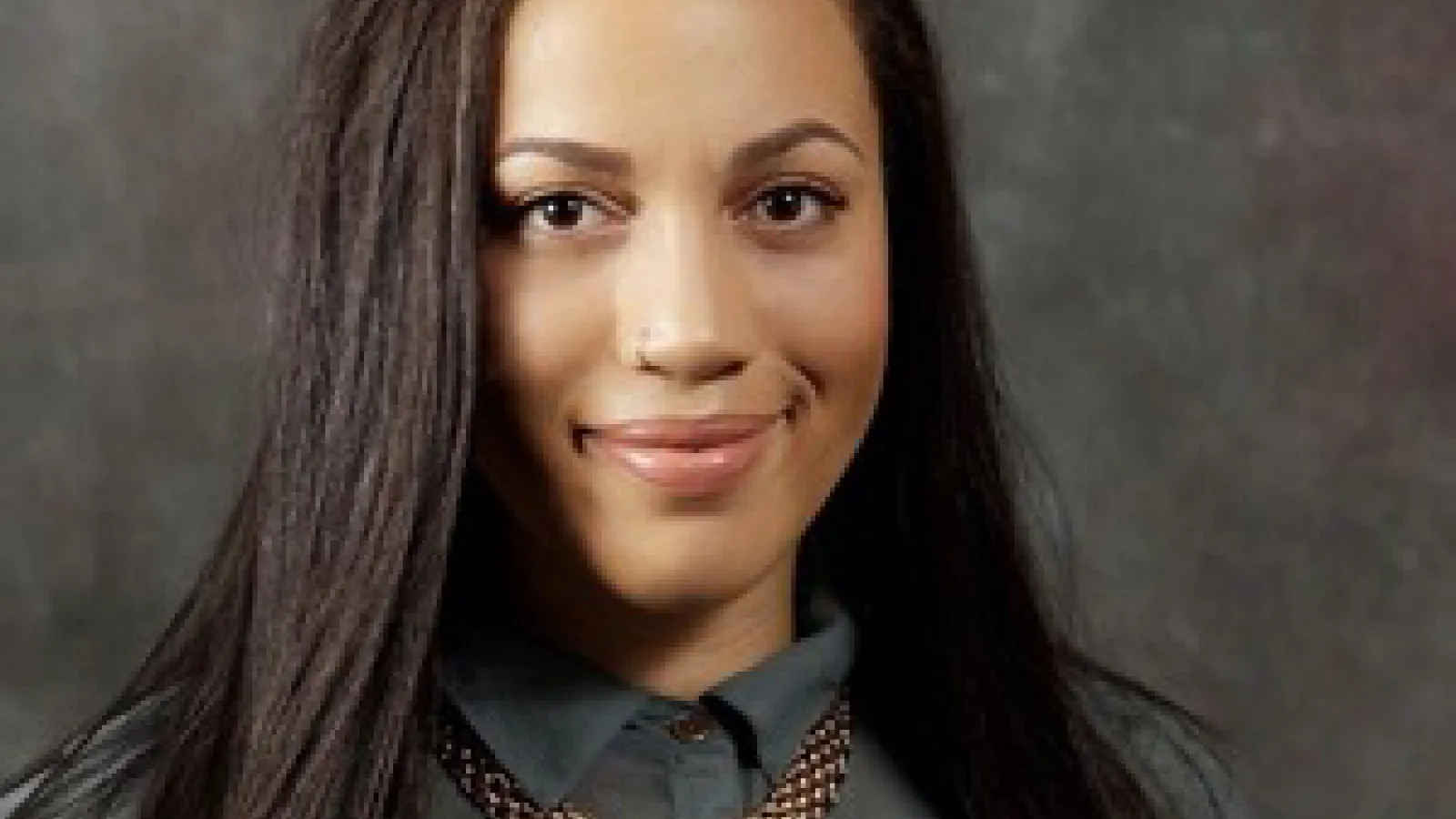 Female graduate student smiles at camera