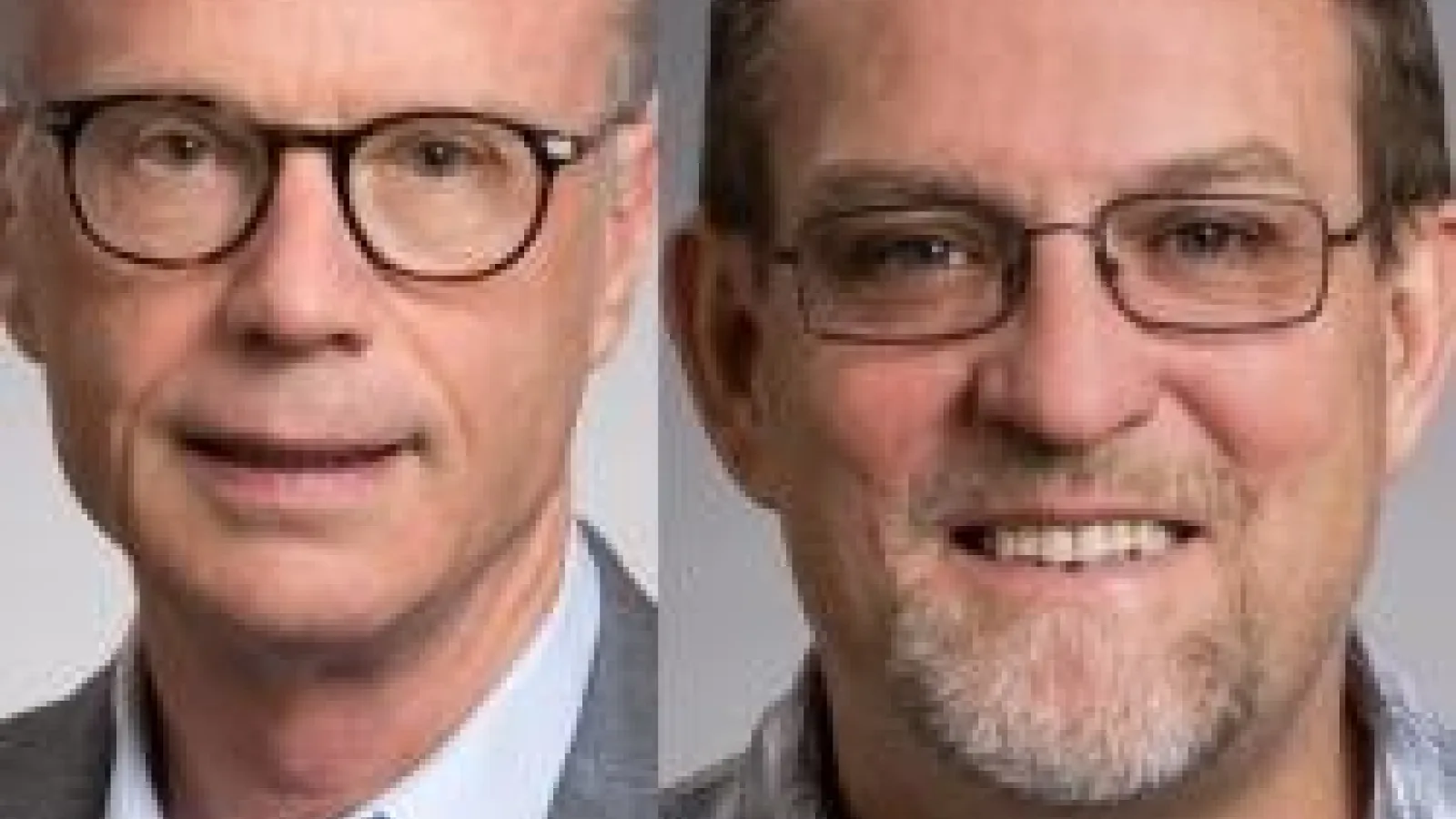 Image of two white men, both wearing glasses and blue button down shirts smiling at the camera